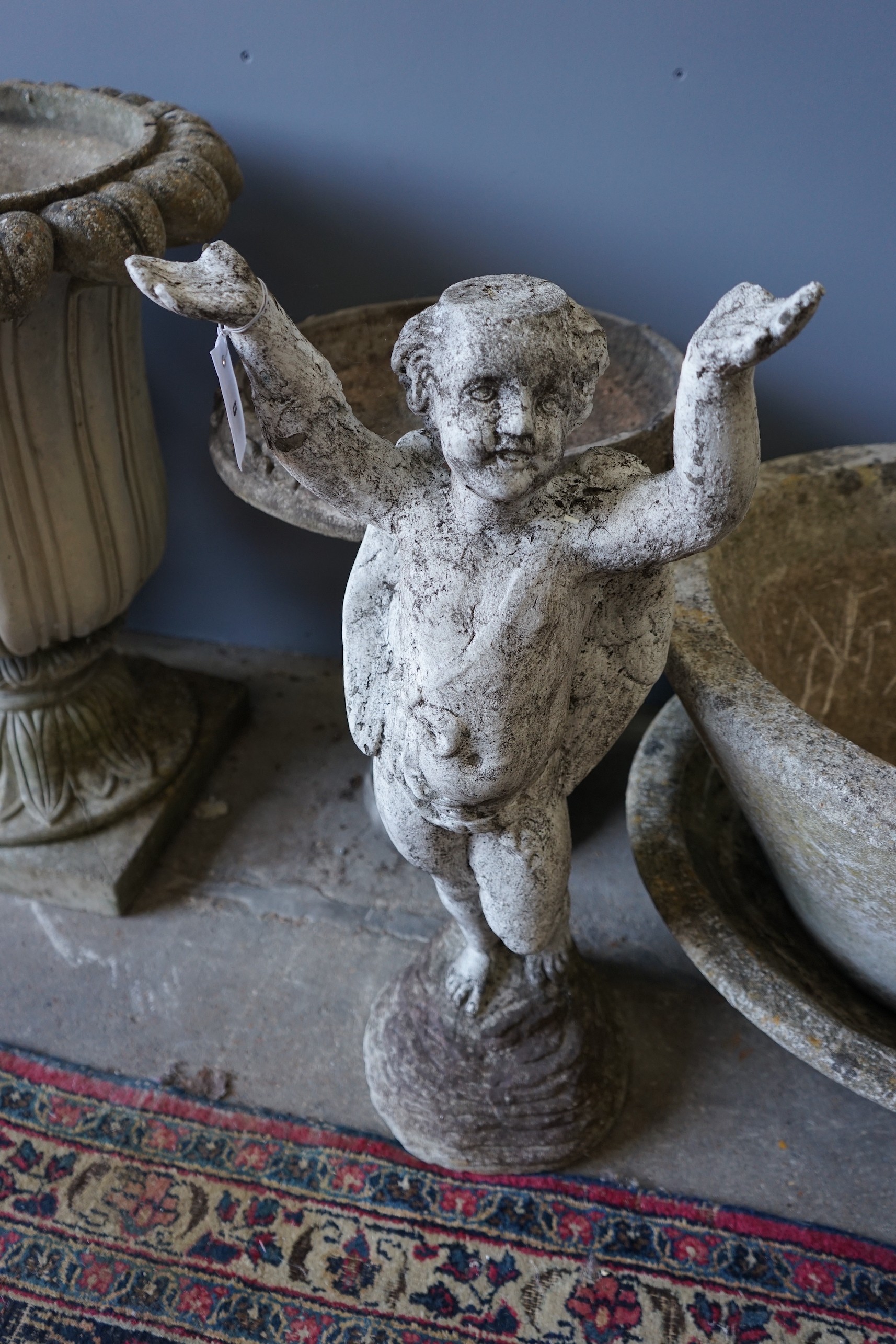 A circular reconstituted stone bird bath, height 50cm, a pair of circular planters and a cherub ornament